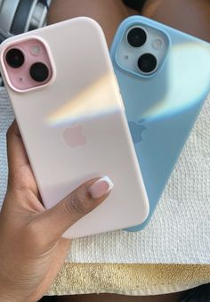 two people holding up their iphones in front of the same phone case as they sit next to each other