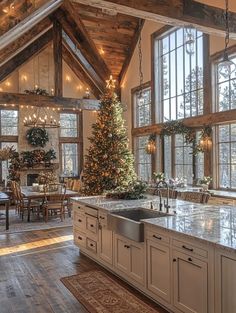 a large kitchen with an island and christmas tree in the center, surrounded by windows