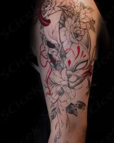 a woman's arm with flowers and skulls on it