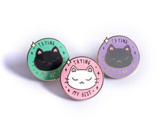 three pins with cats on them sitting next to each other