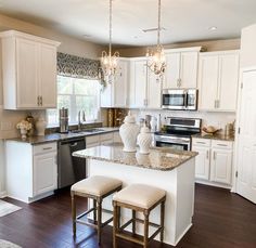 a kitchen with two stools in front of the island and an oven on the other side