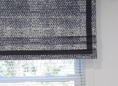 the blinds in this room are covered with black and white fabric