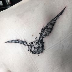 a bird tattoo on the back of a woman's shoulder and chest, with an owl