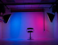 an empty chair sits in front of two spotlights