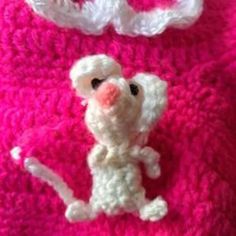 there is a crocheted mouse on the pink blanket