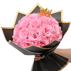 a woman holding a bouquet of pink roses with a gold crown on it's head