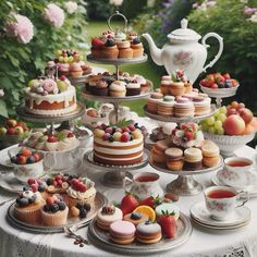 a table topped with lots of cakes and cupcakes next to a tea pot