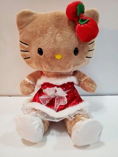 a hello kitty stuffed animal wearing a red dress