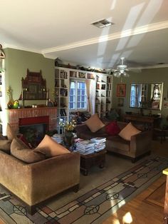 a living room filled with furniture and a fire place in the middle of a room