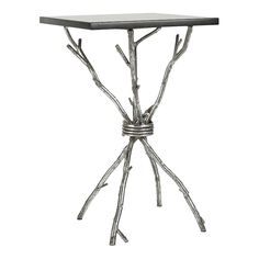 a metal table with branches on it and a glass top in the shape of a tree branch