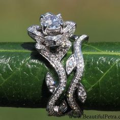 an image of a wedding ring set on a green leafy plant with diamonds in the center