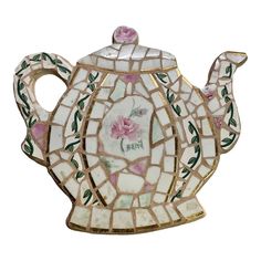 a mosaic tea pot with pink flowers on it