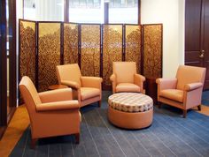 a room divider with three chairs and a footstool in front of it