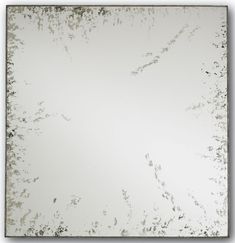 a square mirror with white and silver paint on it