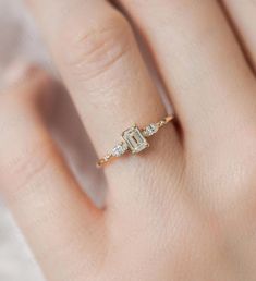 a woman's hand with a diamond ring on top of her finger and the bottom half