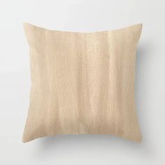 a beige pillow on a white wall