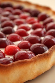 a pie with cherries on it sitting on a table