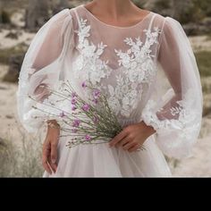 a woman in a wedding dress holding flowers