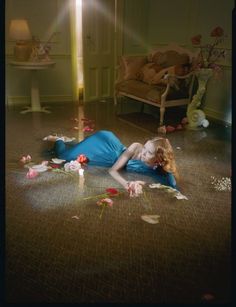 a woman laying on the floor with flowers all around her