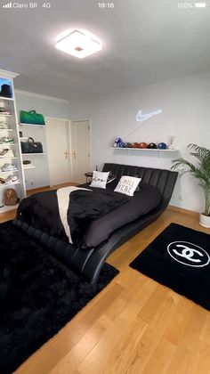 a bed room with a neatly made bed and black rugs