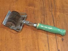 a green handled razor sitting on top of a wooden table