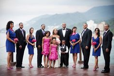 a group of people standing next to each other in front of a body of water