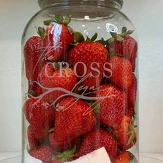 a glass jar filled with lots of strawberries