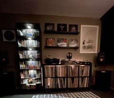 a record player is sitting in front of a book shelf filled with records and cds