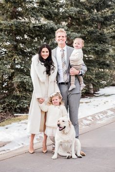 a man, woman and child posing for a photo with their dog