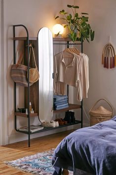 a bedroom with a bed, mirror and clothes rack