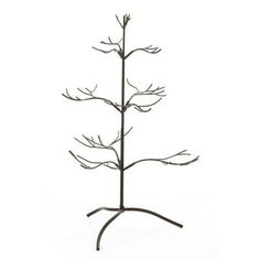 a metal tree with branches and leaves on it's base, against a white background