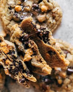 chocolate chip cookies are stacked on top of each other with one cookie broken in half