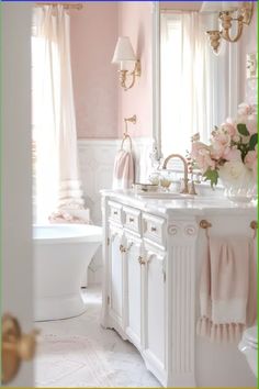 a bathroom with pink walls and white cabinets, flowers on the sink counter top, and chandelier