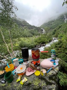 camping supplies are laid out on a rock near a river