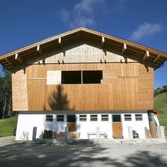 a large wooden building sitting on top of a lush green hillside