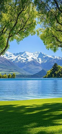 the mountains are covered with snow in the distance, and there is a lake below