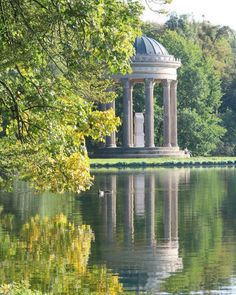 a gazebo sitting on top of a lake surrounded by trees