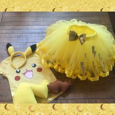 two costumes are sitting on the floor next to each other and one is wearing a yellow dress