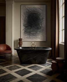 a bathroom with a black bathtub in the middle and a painting on the wall