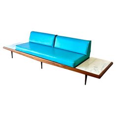 a blue couch sitting on top of a wooden table