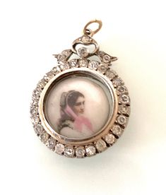 Antique Edwardian Silver 925 Bow design Locket with a gold wash over colour and surrounding glass paste gem stones all gem stones are original and secure as well as in unusually excellent condition - very clean . Locket holds a miniature hand painted ? image on porcelain inside of a young woman with pink scarf - with the stamp mark "5" on its reverse. Diameter of locket is approx 2.5 cm The open jump ring is 18ct Gold This is not marked for silver but has a pawnbrokers details etched on one side Ornate Collectible Rose Cut Diamond Jewelry, Ornate Rose Cut Diamond Collectible Jewelry, Ornate Rose Cut Diamonds Jewelry Collectible, Ornate Rose Cut Diamonds Jewelry For Collectors, Antique Jeweled Jewelry, Antique Jeweled Silver Jewelry, Antique Silver Jeweled Jewelry, Ornate Collectible Diamond Jewelry, Ornate Diamond Jewelry Collectible