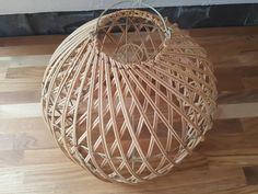 a round wicker basket sitting on top of a hard wood floor