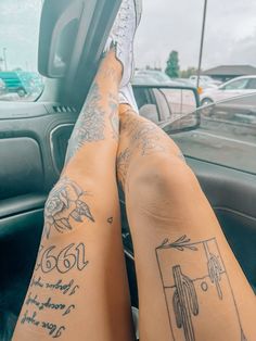 someone with tattoos on their legs sitting in a car