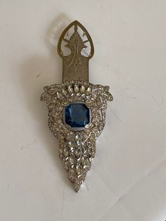 Exquisite vintage scarf clip.  Silver tone metal, white rhinestones and blue stone (I am not sure what kind of stone is it). Elegant Blue Jeweled Brooches, Formal Silver Jeweled Brooches, Silver Jeweled Brooches For Evening, Silver Jeweled Brooches For Formal Occasions, Antique Metal Brooch For Formal Occasions, Formal Rhinestone Costume Brooches, Formal Costume Jewelry Pendant Brooch, Formal Costume Jewelry Brooches With Pendant Shape, Formal Costume Jewelry Brooches In Pendant Shape