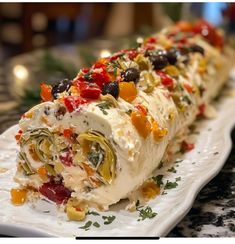 a white plate topped with a burrito covered in lots of veggies and toppings