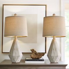 two lamps sitting on top of a table next to a mirror