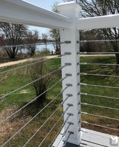 a white metal fence in the middle of a grassy area