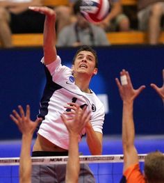 a man hitting a volleyball over the net