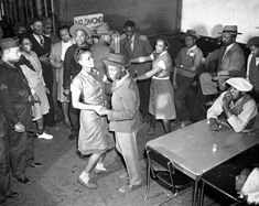 an old black and white photo of people dancing in a room with many other people