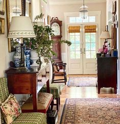 a living room filled with furniture and a clock on top of a wall next to a doorway